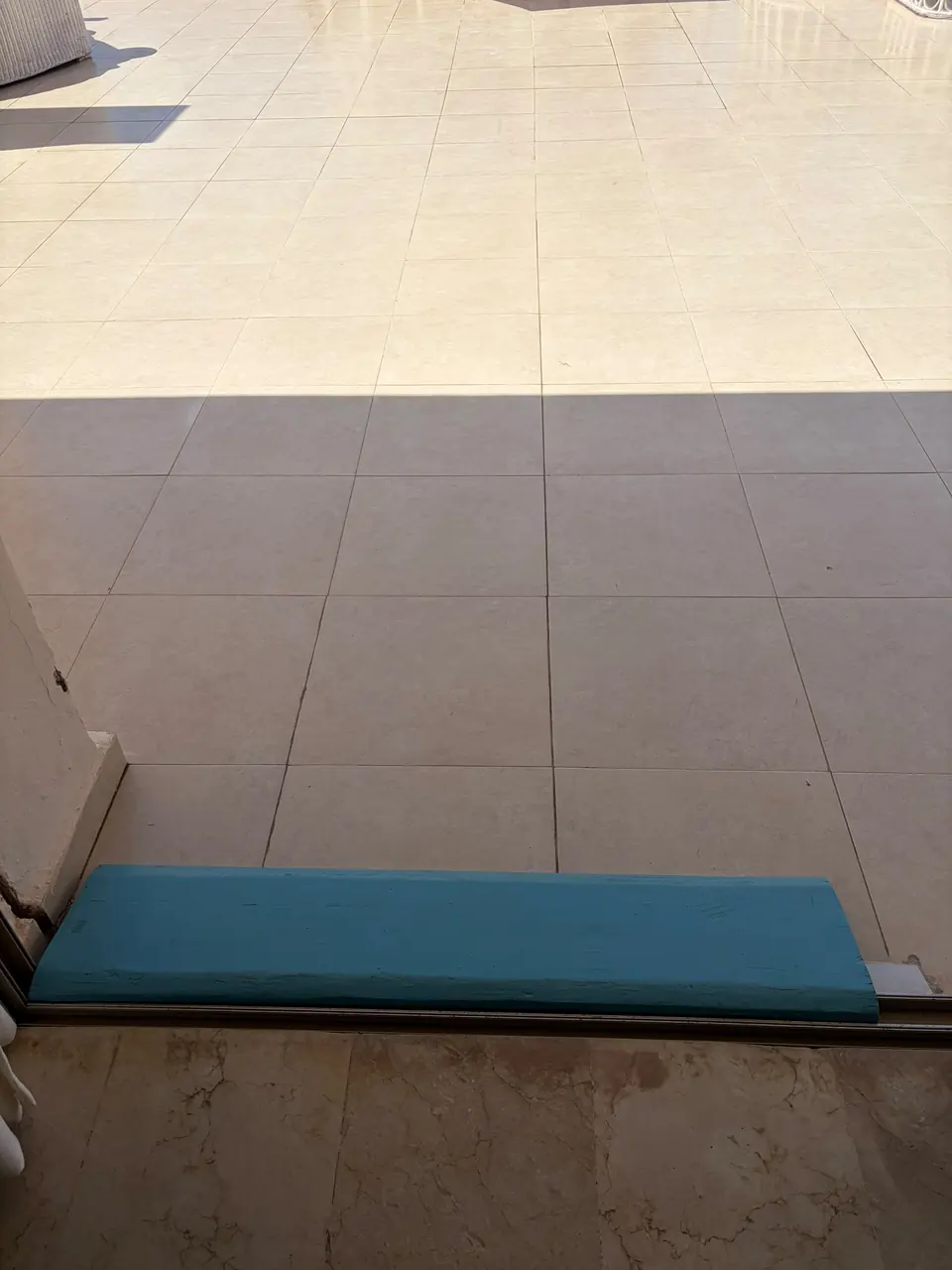 Rampe posée sur le rail de la baie vitrée pour accéder à la terrasse