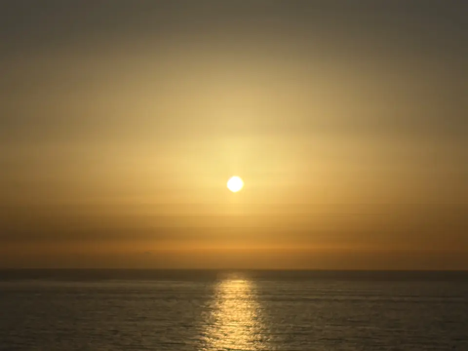 Reflet doré du soleil couchant sur l’océan, vu depuis la terrasse