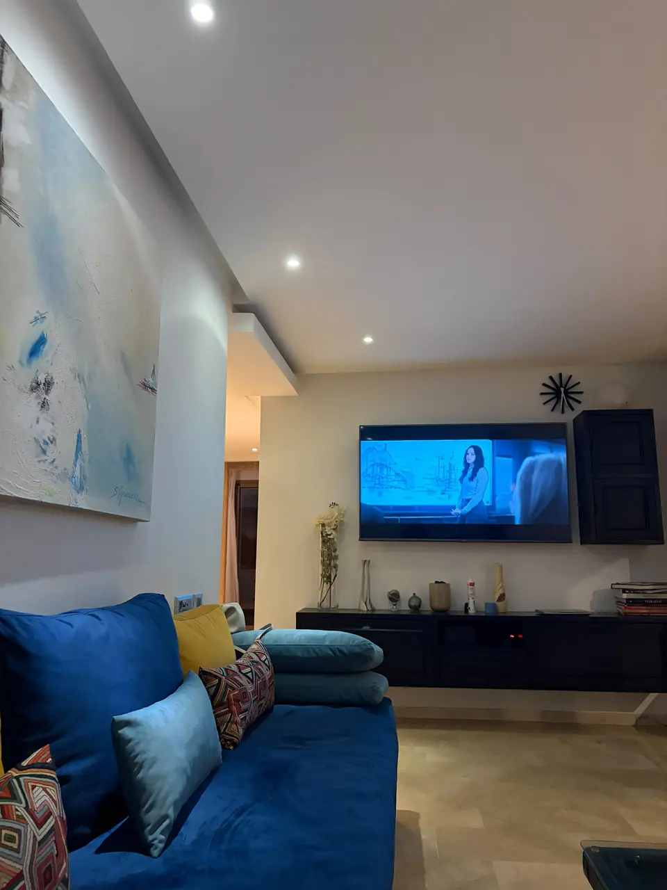 Salon avec télévision à écran plat et canapé bleu