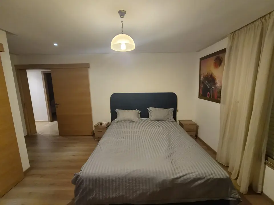 Lit double de la suite parentale et porte coulissante en bois