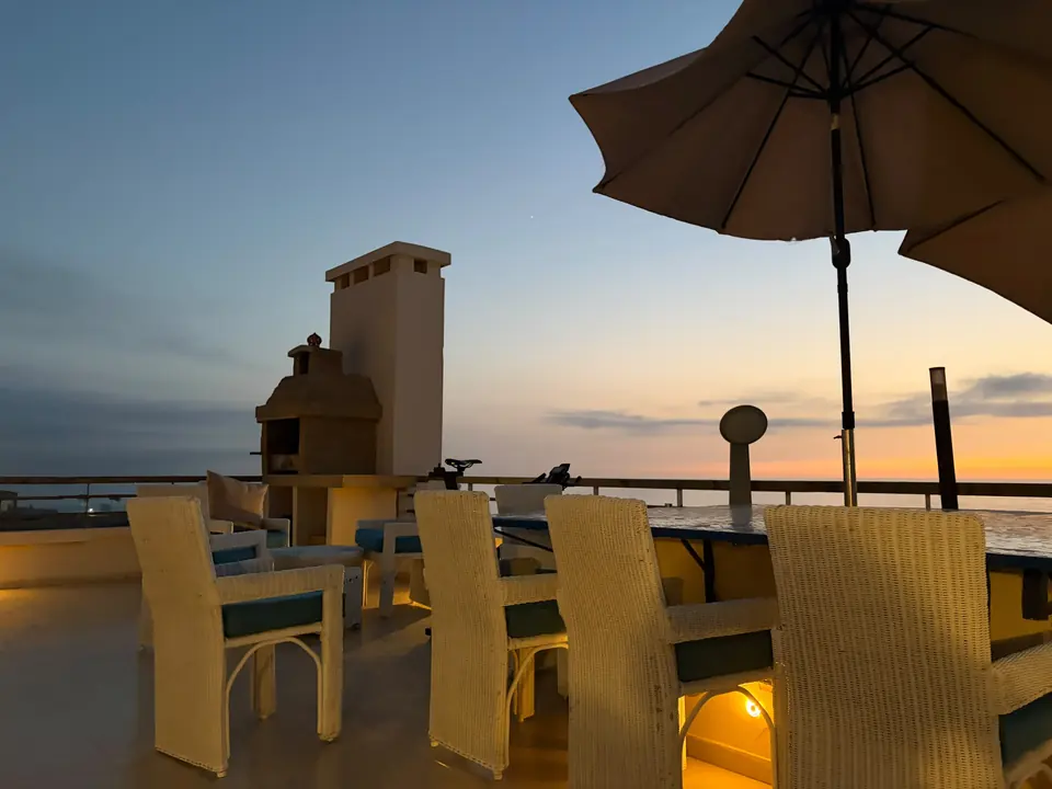 Barbecue maçonné et table d’extérieur de la terrasse à la tombée de la nuit