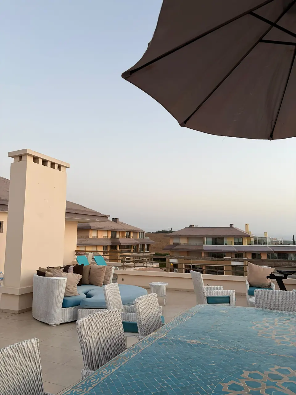 Terrasse avec salon d’extérieur et vue sur les toits de la résidence